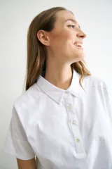 Remera azul marino de algodón con cuello polo, manga corta con detalle de broderie y tapeta con botones.