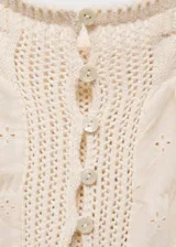 Top blanco con tirantes finos, cierre de botones en la parte delantera, cuello escotado, diseño recto, detalles calados y tejido de punto medio.