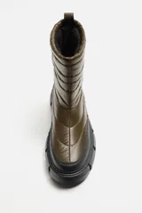 Bota corta color verde militar con diseño acolchado, tirador trasero y suela track negra.
