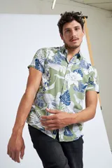 Camisa manga corta con estampado floral en tonos verdes y azules, diseño de corte slim y cartera abotonada.