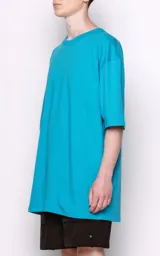 Remera turquesa de corte extra oversize con hombros caídos, cuello redondo y doble costura.