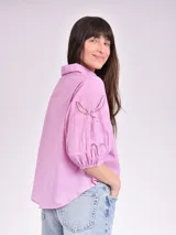 Camisa blanca de mangas 3/4 con detalles de calado en las mangas.