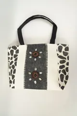 Bolso tipo tote con estampado animal print y detalles de decoración con conchas marinas.