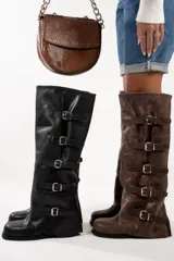 Botas altas color marrón claro, de cuero gamuzado, con caña alta y múltiples correas horizontales con hebillas metálicas.