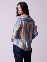 Camisa de gasa estampada a rayas verticales de color celeste, blanco, naranja y marrón. Tiene cuello con solapa, escote en V, abertura central con botones, bolsillo aplicado en el pecho y terminación anudada en la parte delantera.