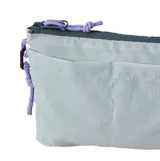 Bolso de mano tipo sobre o cartera Rip Curl The Search Crossbody, color celeste pálido con textura ripstop. Presenta un bolsillo frontal exterior y cierre superior con tiradores de cordón morado. Incluye logo de 'Search RIPCURL' en la parte inferior derecha.