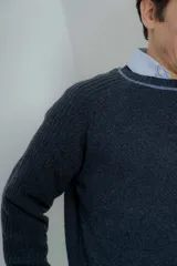 Sweater azul marino de hombre con cuello redondo y puños acanalados en color marrón.