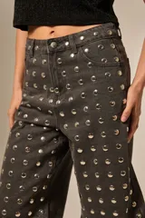 Bermuda de jean gris oscuro, tiro alto, corte holgado y recto, con apliques de strass plateados distribuidos por toda la prenda.