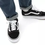 Zapatilla negra de skate con diseño clásico, característica línea blanca y suela de goma.