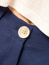 Pantalón de lino negro de tiro alto, con pierna ancha y pinzas delanteras, elástico en la pretina trasera y bolsillos laterales.