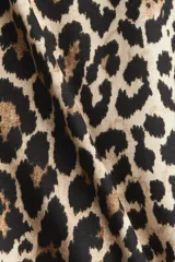 Remera oversized de punto de algodón con estampado de leopardo, cuello redondo ribeteado, hombros caídos y bajo recto.