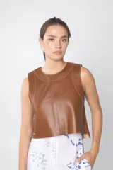 Chaleco corto marrón de cuero con cuello redondo y costuras a la vista.