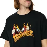 Remera negra Thrasher con estampado de un personaje con anteojos y llamas.