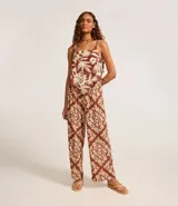 Pantalón pantalona con cintura alta, cintura ancha con botones forrados en los laterales y estampa tropical estilo pañuelo con flores.