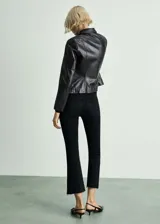 Pantalón de jeans negro de tiro alto, corte flare y bajo deshilachado.