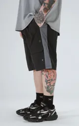 Bermuda negra con paneles laterales grises, cintura elastizada con cordón de ajuste y bolsillos laterales.