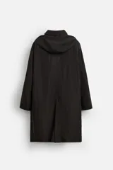 Trench negro relaxed fit confeccionado en tejido técnico ligeramente acolchado, con cuello alto y capucha desmontable, manga larga, bolsillos de vivo en pecho y de solapa en cadera, bajo con abertura en centro espalda y cierre frontal de cremallera oculta por solapa con botones a presión.