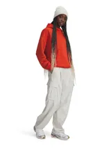 Pantalón cargo Under Armour Unstoppable para mujer, color blanco hueso, de corte holgado, con cintura elástica, bolsillos laterales y logo bordado en la pierna.