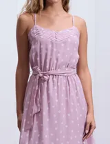 Vestido midi de gasa color lila con estampado de lunares blancos, escote en V, breteles finos regulables, espalda elastizada, delantera plisada con botones forrados y forro interno a tono.