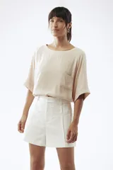 Short de corte clásico, color beige, con bolsillos laterales y cintura alta.