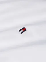 Camisa blanca de popelín de mezcla de algodón elástico, corte regular, cuello inglés, puños con botón y logo de Tommy Hilfiger bordado en el pecho.