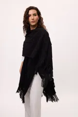 Ruana negra con flecos de algodón.