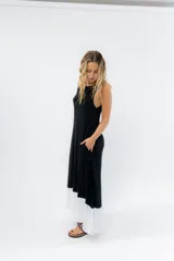 Vestido largo negro con base blanca, de corte suelto y sin mangas.