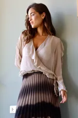 Blusa color beige de gasa cruzada con manga larga y volados.