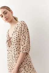 Vestido corto con estampado de animal print, mangas tres cuartos y cut-out frontal con lazo.