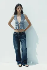 Top amarillo con estampado de cuadros vichy blancos, escote en pico, sin mangas, con detalle de elásticos en la cintura y cierre frontal con lazadas.