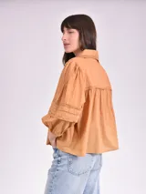 Blusa color beige con cuello mao, escote en V y mangas 3/4 con elástico en los puños.