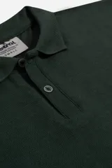 Polo de manga larga color verde oscuro, con cuello clásico y tapeta de dos botones.