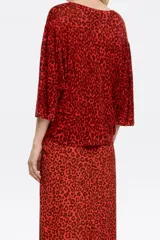 Jersey de lino color rojo con estampado animal print en marrón oscuro, corte recto, escote redondo, manga 3/4 con puño estrecho y sisa cuadrada con fruncido en el hombro.