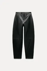 Pantalón de cuero negro de tiro medio, con pinzas delanteras, bolsillos laterales ocultos y corte holgado.