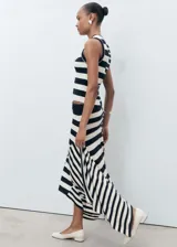 Falda midi de punto con estampado de rayas horizontales en blanco y negro. Presenta cintura elástica, corte evasé y bajo asimétrico.