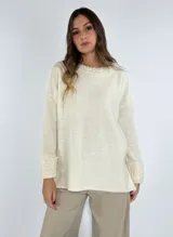 Sweater color crudo con detalles de encaje en los puños y corte holgado.