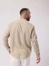 Camisa de manga larga color crudo, confeccionada en lino. Presenta cuello mao y cierre frontal con botones. Marca La Dolphina.
