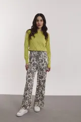 Pantalón de corte amplio con estampado de flores en tonos grises, amarillos y rosados.