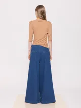 Jeans de corte wide leg y tiro medio-alto, con pinzas en la cintura que aportan forma y volumen.
