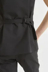 Chaleco negro cruzado con botones y bolsillos sastreros.