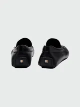 Mocasines de cuero negro marca BOSS, con suela antideslizante.