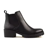 Bota Chelsea de cuero negro con elásticos laterales, caña baja, suela track y taco ancho.
