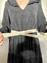 Cinturón de cuero negro, delgado y liso, con terminación en lazo.