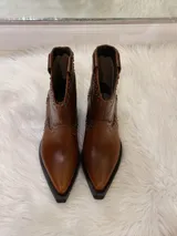 Botas cortas de cuero color marrón con punta fina, taco cuadrado y apliques de tachas metálicas.
