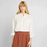 Camisa blanca de lino con mangas largas y bolsillo en el pecho.