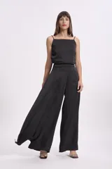 Crop top negro de satén con breteles finos regulables y corte holgado.