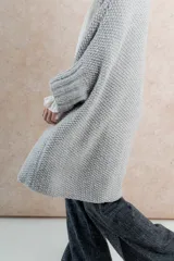 Saco gris tejido a mano con punto inglés, corte oversize y largo por debajo de la cola.