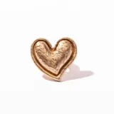 Anillo dorado con forma de corazón con textura irregular.