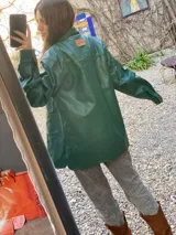 Campera de cuero marrón con cuello clásico, cierre frontal con botones y bolsillos con solapa.