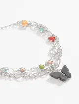 Pulsera de doble cadena con dije de mariposa y detalles en piedras de colores.
